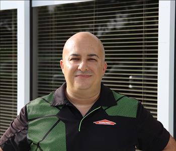 male employee with green and black shirt smiling