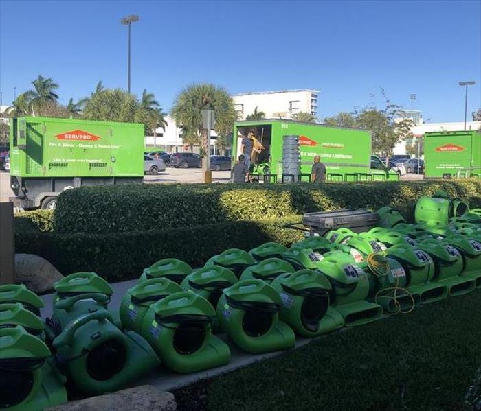 green SERVPRO air movers with SERVPRO trucks in background