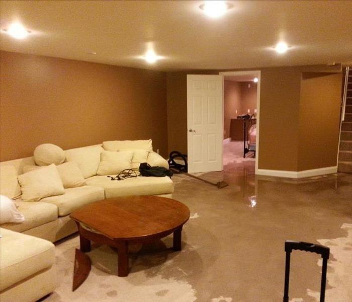 living room with white sofa and wet carpet